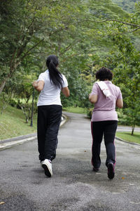 Rear view of couple walking on road