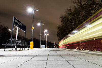 Illuminated street lights against clear sky at night