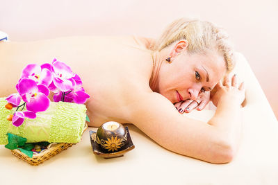 High angle view of shirtless mature woman lying in spa