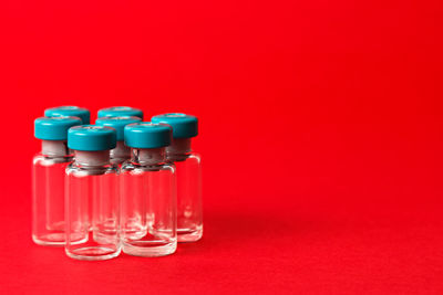 Close-up of glasses on table against red background