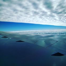 Airplane flying over landscape against sky