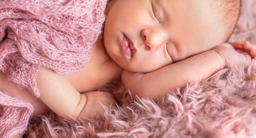 Baby girl sleeping on bed