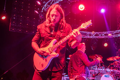 Full length of man playing guitar at night