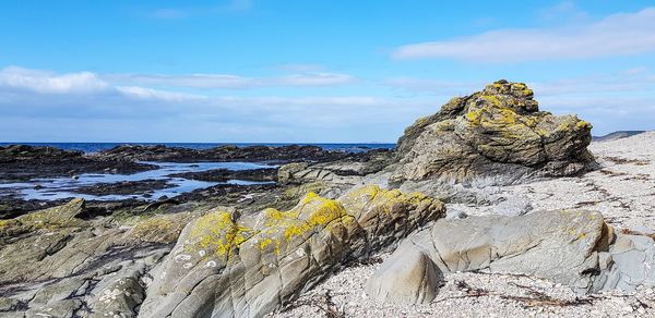 Rock formations by sea against sky