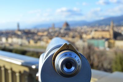 Close-up of coin-operated binoculars against buildings in city