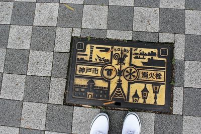 Low section of person standing on footpath