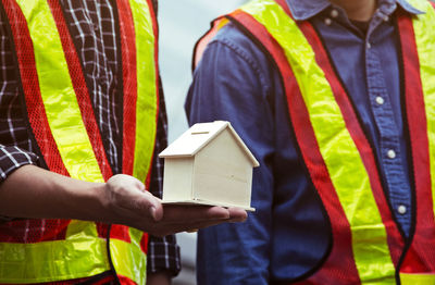 Midsection of engineers with model house