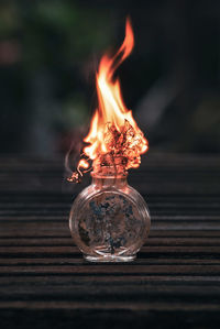 Close-up of burning candle on table