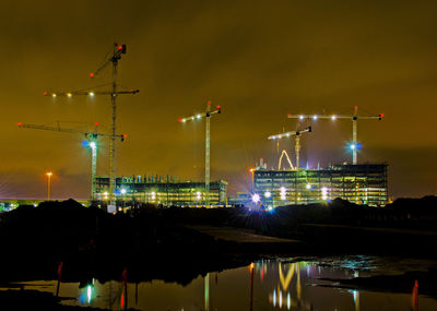 Illuminated commercial dock against sky at night