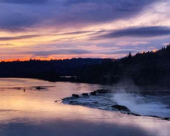 Scenic view of lake against sky at sunset