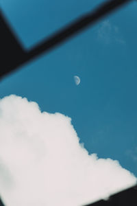 Low angle view of moon in blue sky