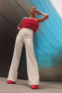 Full length of young woman  stands near a mirrored wall