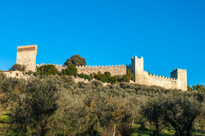 Low angle view of fort against clear blue sky