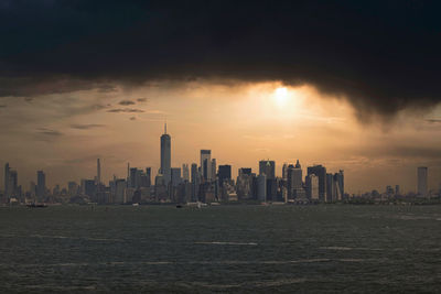 Skyscrapers in city against sky during sunset