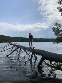 Man standing by lake against sky