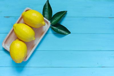 Lemons in plate on wooden table