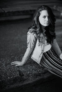 Portrait of a beautiful young woman sitting outdoors