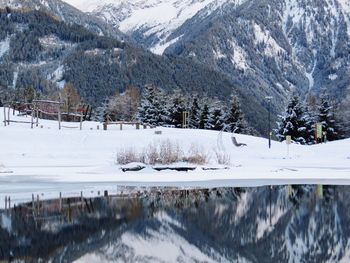 Reflection of mountains in river on snowed landscape