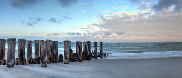 Dawn over a dilapidated pier on the beach in port royal in naples, florida.