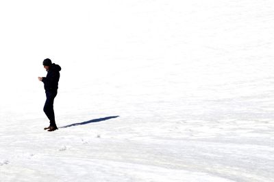 Side view of man standing on snow