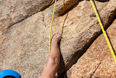 Close-up of shirtless man climbing rock