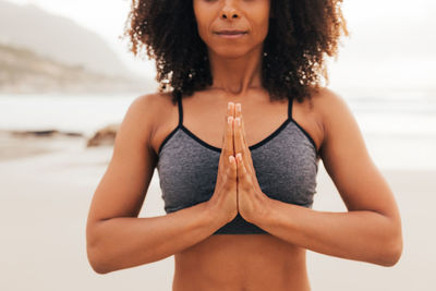 Portrait of young woman standing at beach