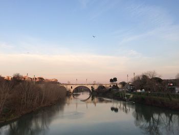 Bridge over river against sky during sunset