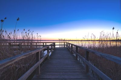 Pier over sea against sky during sunset