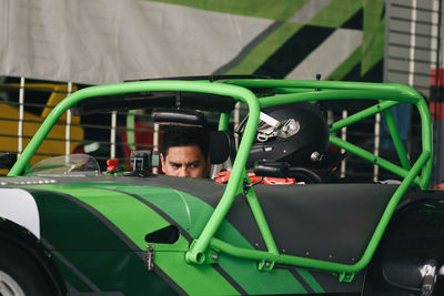 Side view of mechanic repairing car at garage