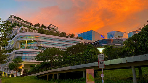 Low angle view of illuminated buildings against sky during sunset