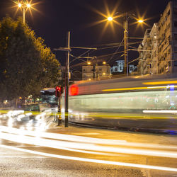 Blurred motion of cable car on road in city at night