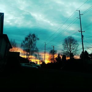 Power lines against sunset sky