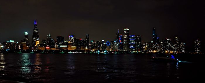 Illuminated buildings against sky at night