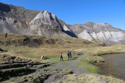 People walking on mountain against sky