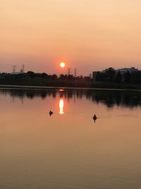 Scenic view of lake against orange sky