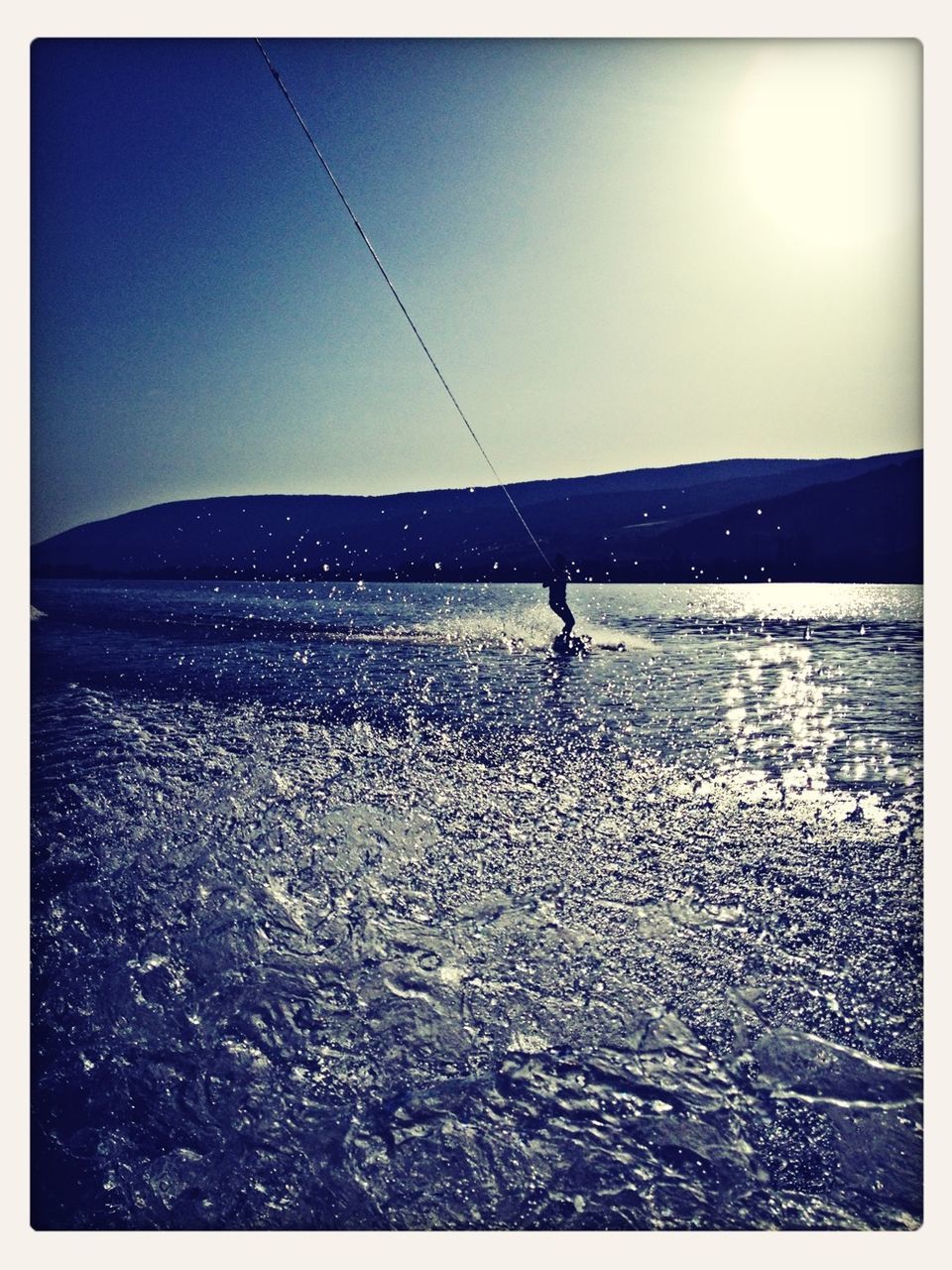 transfer print, leisure activity, lifestyles, full length, auto post production filter, men, sea, extreme sports, sky, tranquil scene, adventure, scenics, tranquility, standing, clear sky, unrecognizable person, nature, water