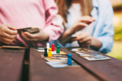 Close-up of woman holding paper with hand on table