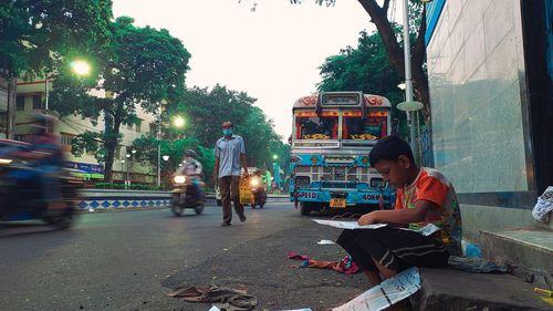 People sitting on street in city