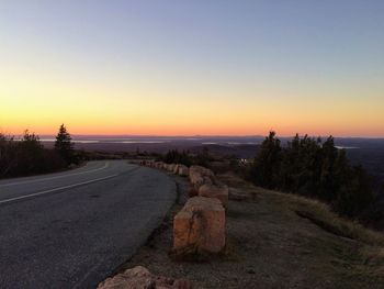 Scenic view of road against clear sky during sunset