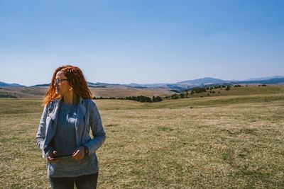 Woman standing on field against sky