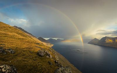 Scenic view of sea against sky with rainbow