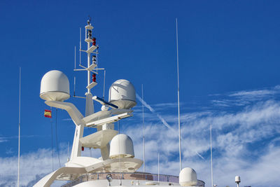 Low angle view of communications tower against blue sky