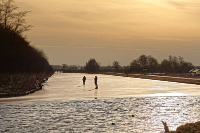 Scenic view of lake against sky during winter