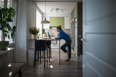Side view of young man sitting on table