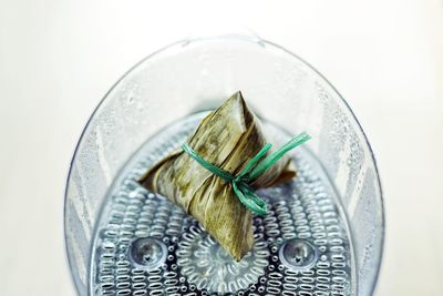 High angle view of food in a steamer against white background