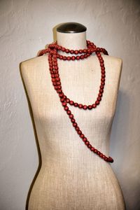 Close-up of tied hanging on rope against wall