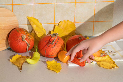 Cropped hand of woman holding pumpkin