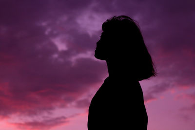 Silhouette woman standing against sky during sunset