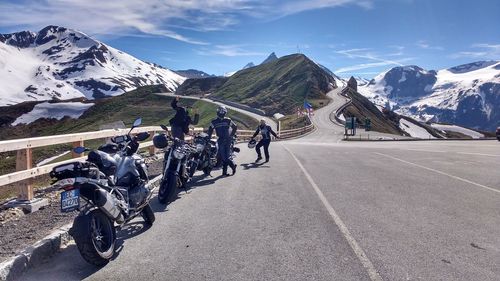 Rear view of people riding motorcycle on road