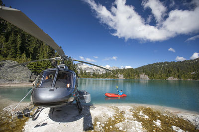 Active man paddling next to his helicopter.